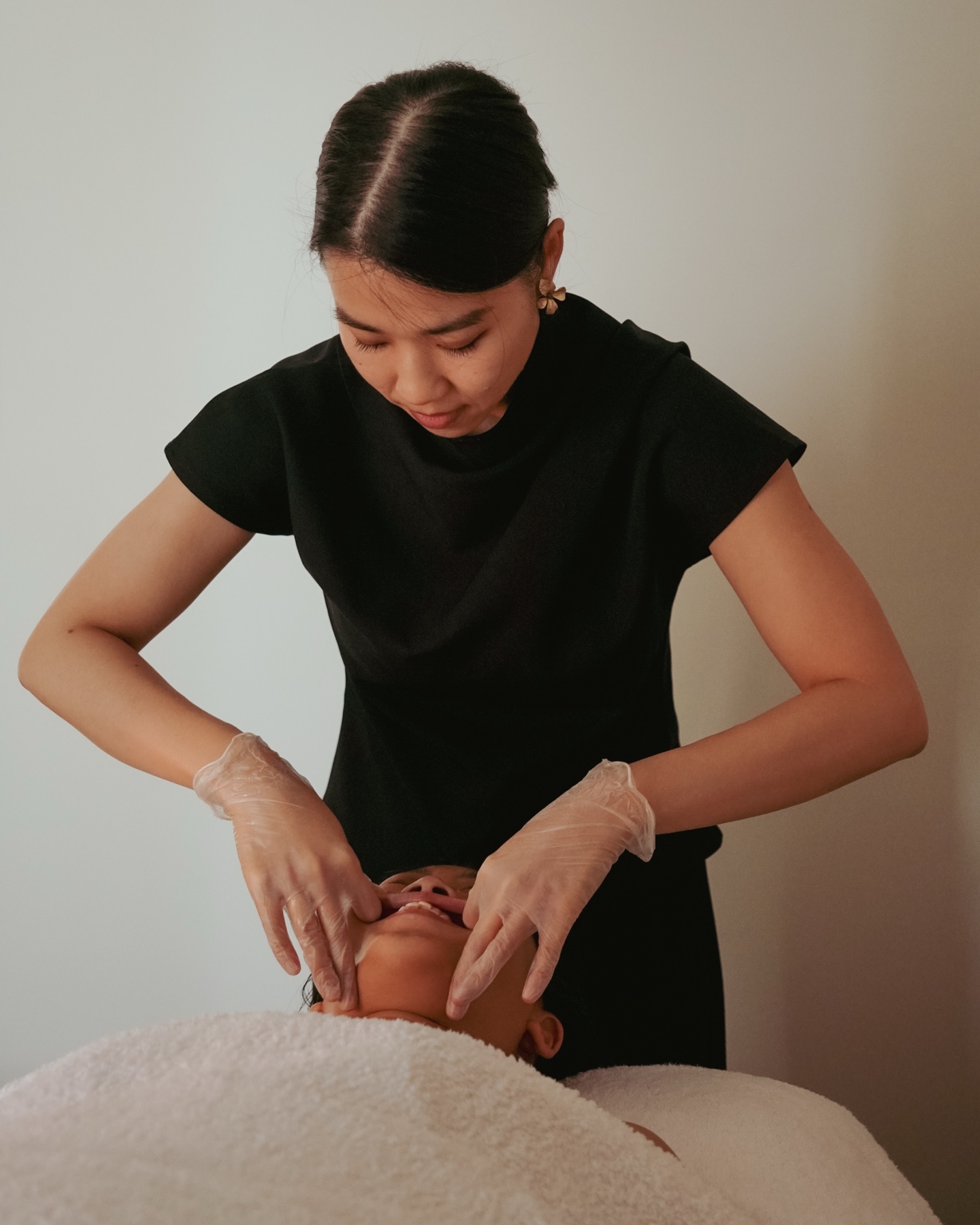 MUKA facial specialist performing an intentional sculptural treatment